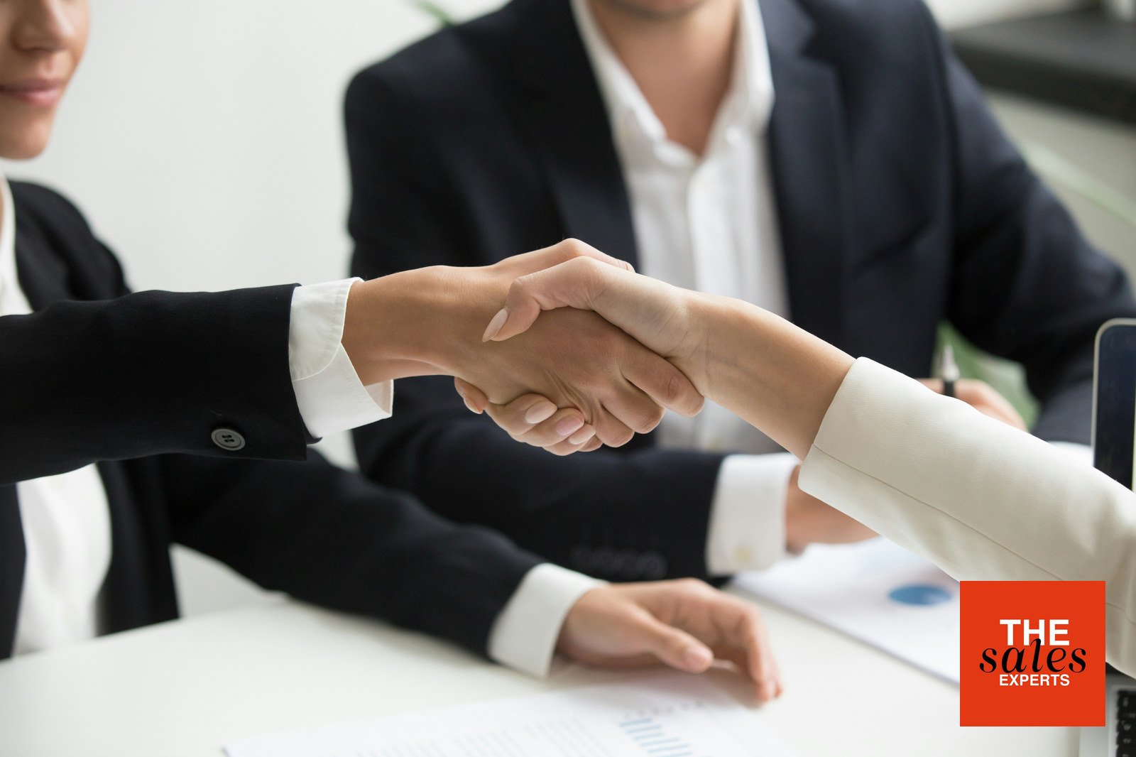 Business professionals shaking hands after a sales salary discussion