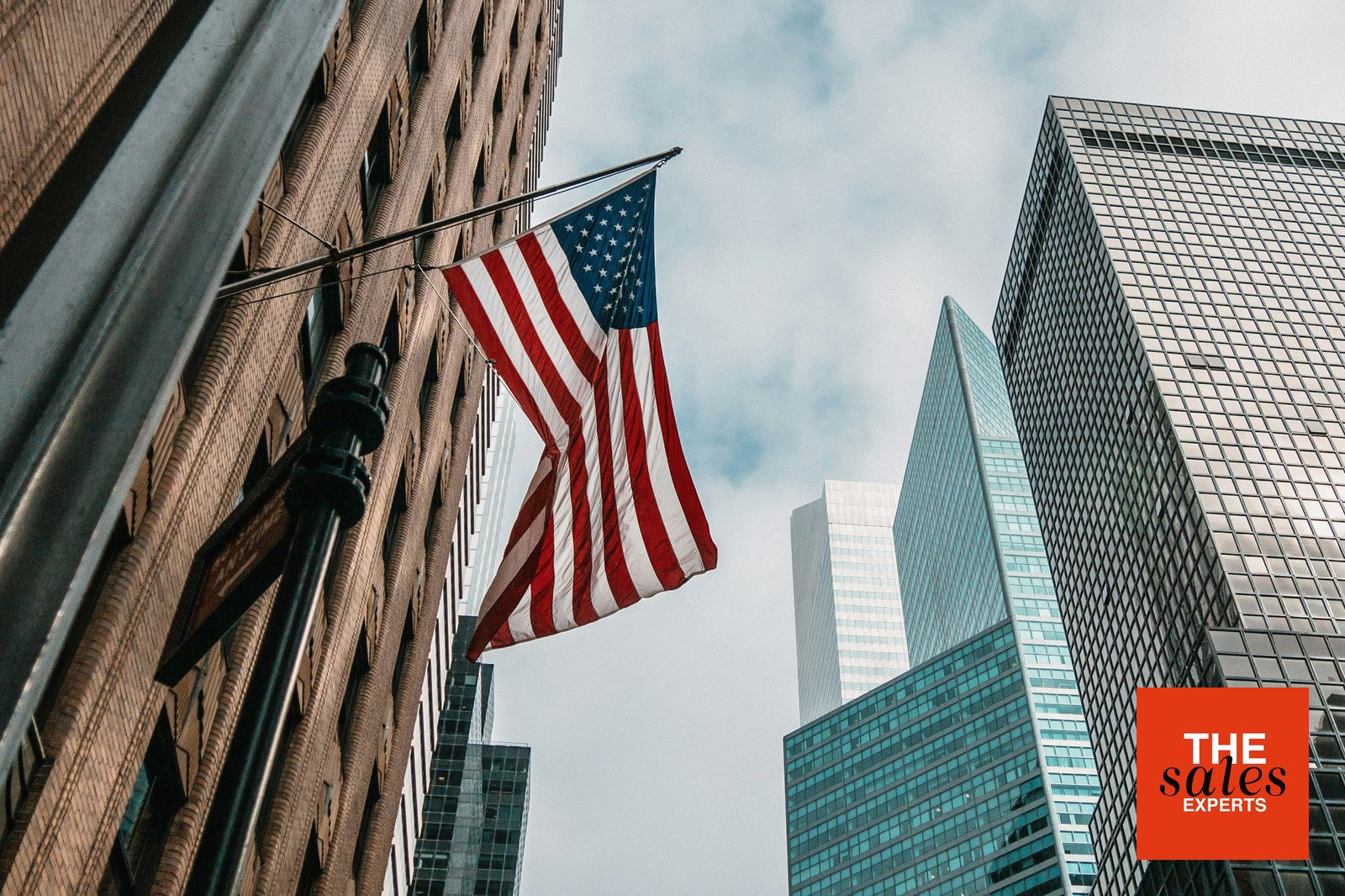 American flag among city office towers representing US sales expansion